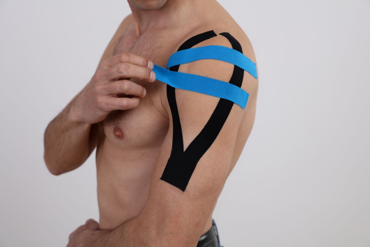 Kinesiology taping. Sport man exercising injury, shoulder pain. Alternative medicine concept